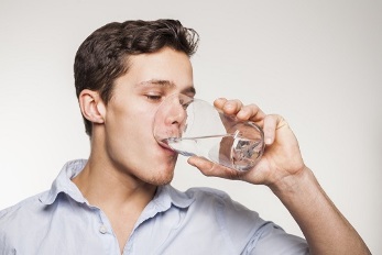 hand-washing down the pills with a glass of water